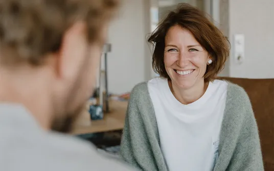 Frau lächelt, nachdem ihr das attraktive Angebot für Ihre Heizung gemacht wurde.